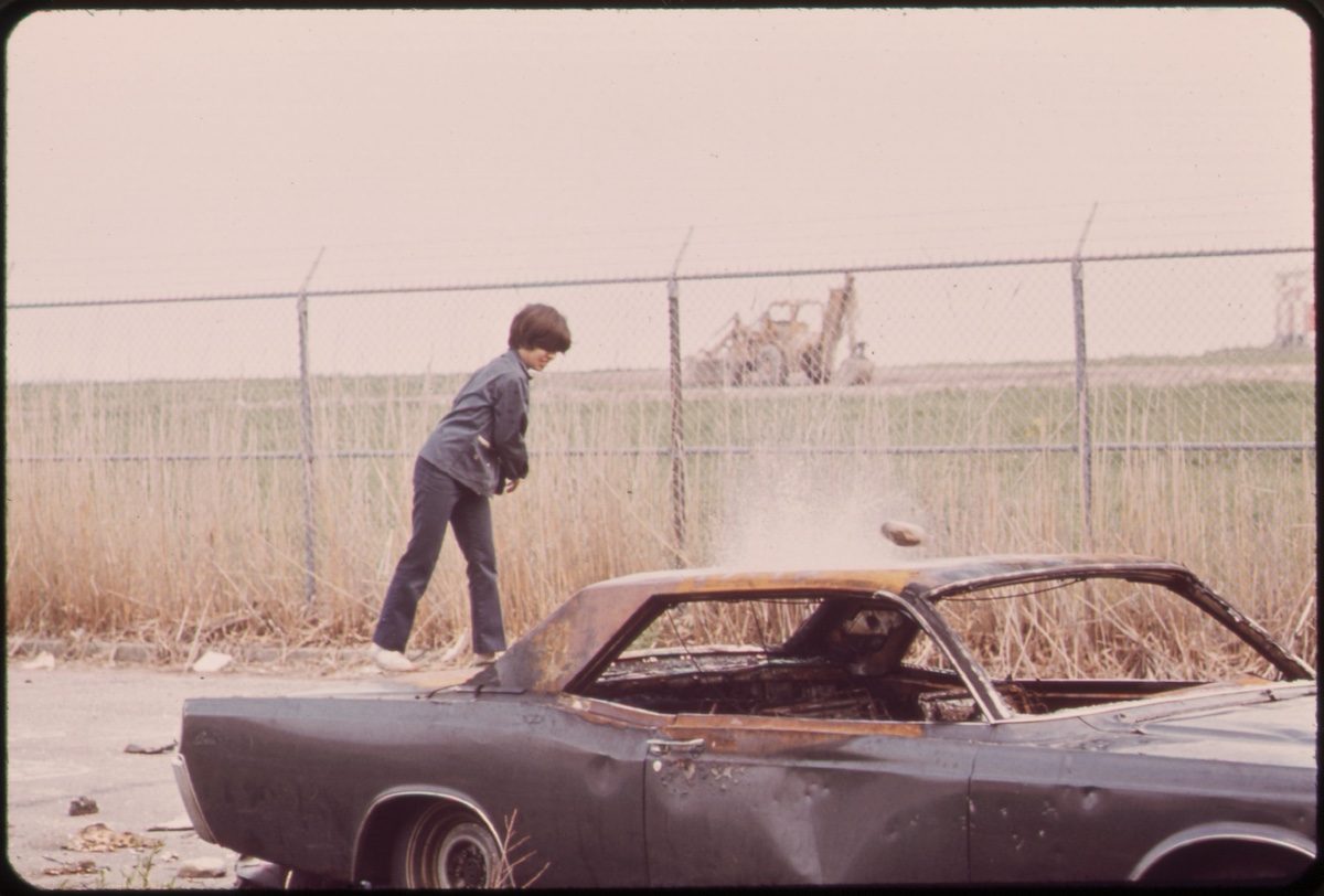 Logan Airport Area. Neighborhood Boys Play Rough with an Abandoned Car behind the Wood Island Station of the MBTA (Metropolitan Boston Transit Authority) 05/1973