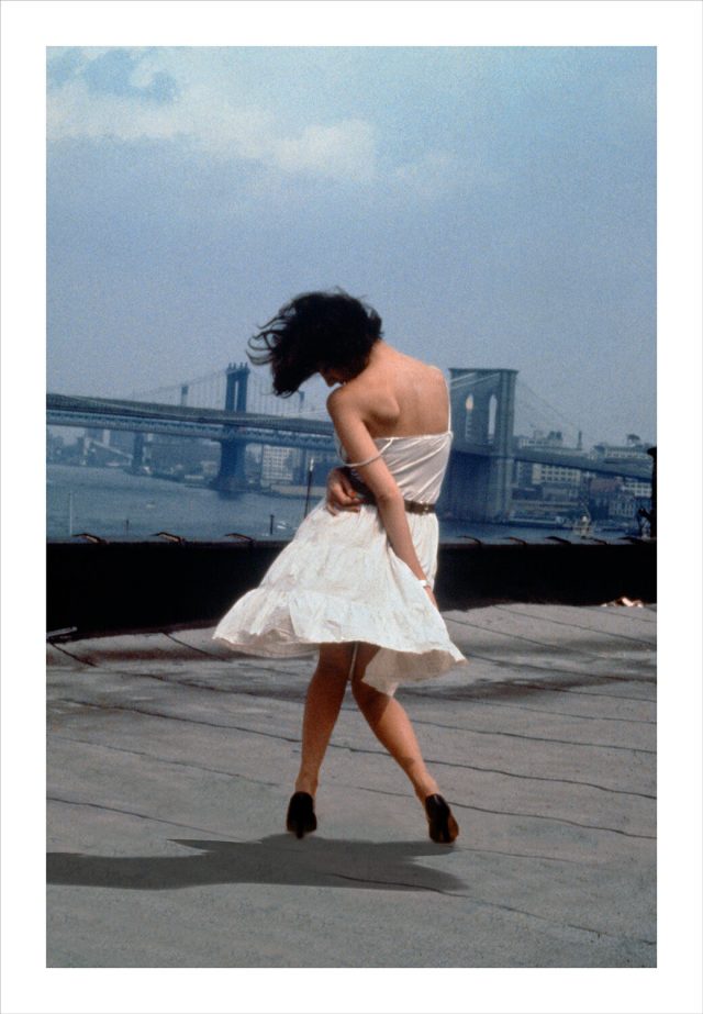 Imagem de um homem vestindo terno com o corpo contorcido sobre um terraço em Nova York. Fotografia de Robert Longo