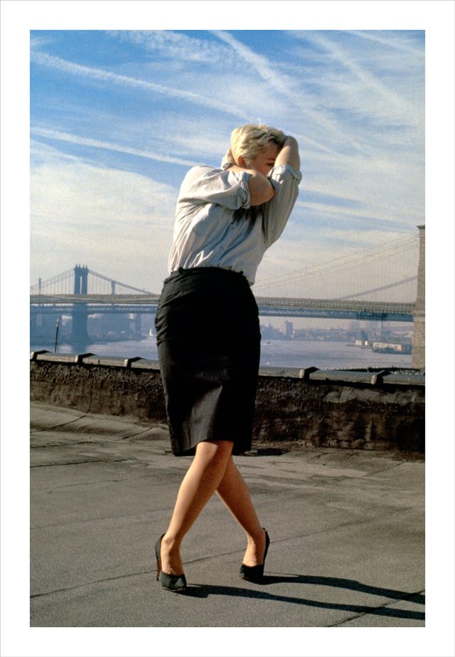 Imagem de uma mulher vestindo roupa formal com o corpo contorcido sobre um terraço em Nova York. Fotografia de Robert Longo