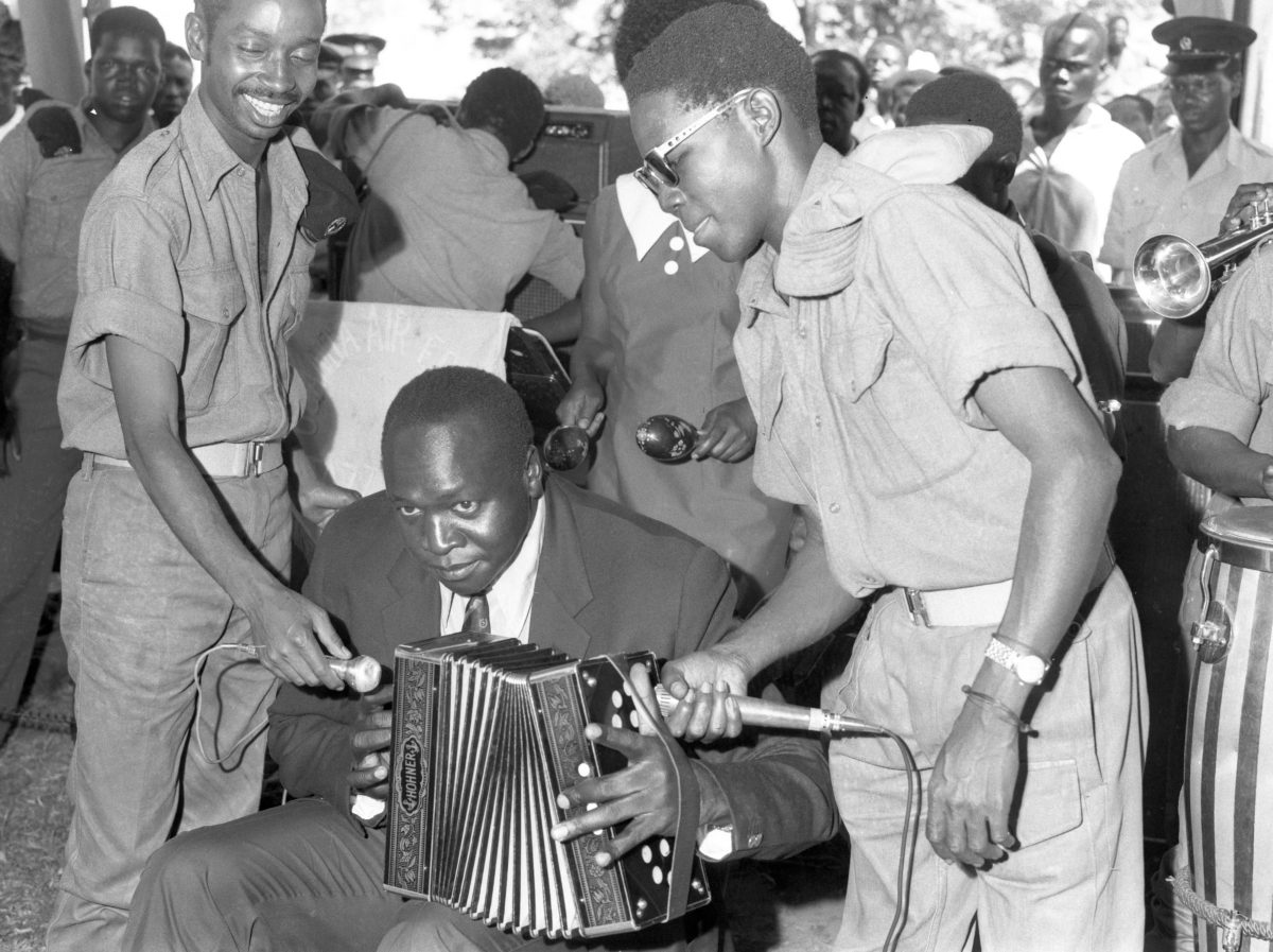 Idi Amin playing the accordion at Buvuma Island in 1971. Photograph- Uganda Broadcasting Corporation